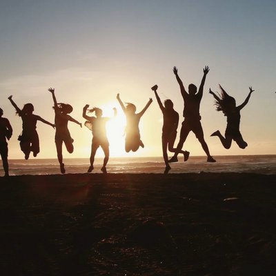 Happy persons jumping in front of sunset