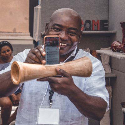 Happy man with a phone and improvised tube speakers. Langly logo in the corner.