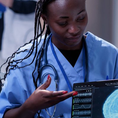 Healthcare professional examining a tablet showing brain scan data in a clinical setting. Langly logo in the corner.