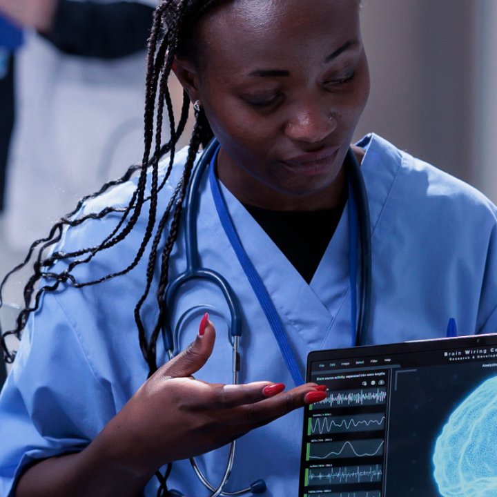 Healthcare professional examining a tablet showing brain scan data in a clinical setting. Langly logo in the corner.